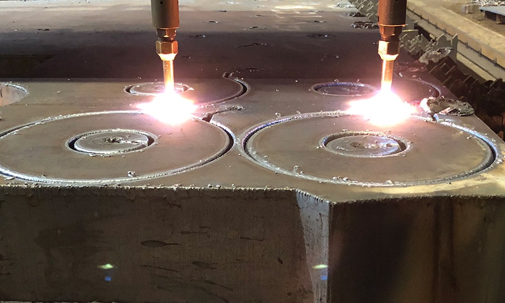 Machine using heat to cut two steel plates at steel plate supplier in Pennsylvania