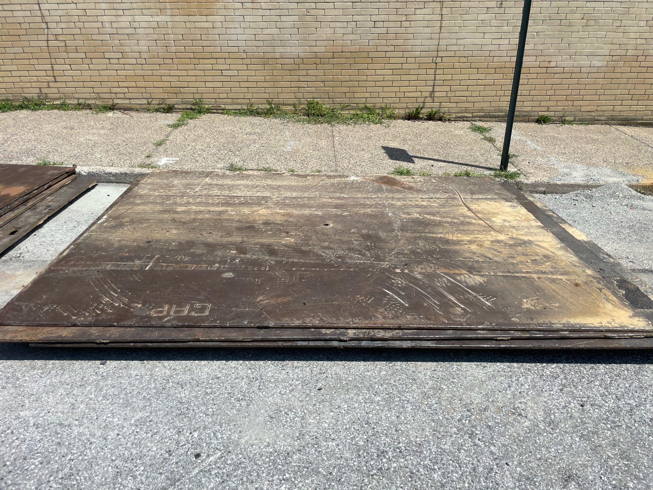 A stack of Delaware Valley Steel road plates stacked on site at a road project.