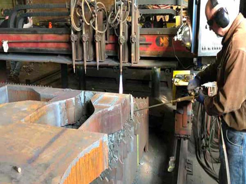 Man slicing steel in shop